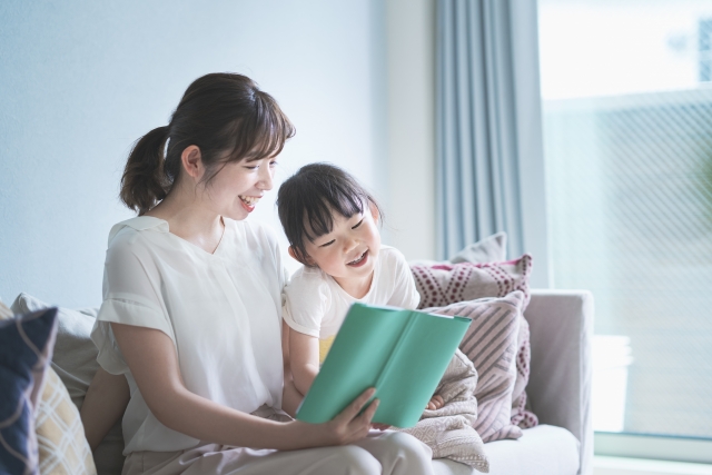 子どもに本を読む女性